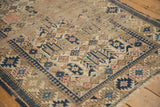 Hard wear visible on navy blue and blush geometric buds of an antique Caucasian rug.