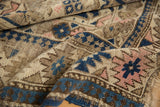 Geometric blue and blush patterns on the character-rich pile of an antique Caucasian rug.