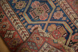 Hand-knotted antique Kurdish rug with red and blue sections skillfully joined, showcasing its storied character.