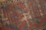 Worn pile revealing foundation within madder red hook and latch geometric patterns of the antique Caucasian rug.