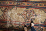 Antique Serab runner's ivory field and geometric medallion showing wear and exposed foundation.