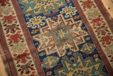 Distinctive cherry red floral border frames indigo blue geometric pinwheel motifs.