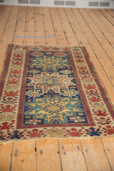 Antique Caucasian rug's end, with geometric field and cherry red oversized floral border.