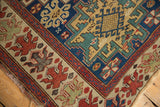 Antique Caucasian rug corner shows unusual oversized floral border and indigo geometric field.