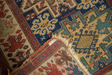 Antique Caucasian rug with cherry red oversized floral blossom border and indigo field.