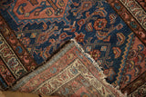Folded corner of a Borchalou rug, showcasing its woven foundation, secured edges, and indigo and blush motifs.