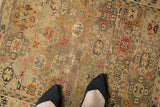 Antique Caucasian rug with repeating floral motif in beige, blush, tangerine, showing even wear.