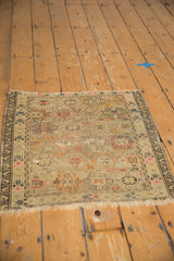Corner of an antique Caucasian rug, geometric patterns, blush, orange, and faint foundation visible.