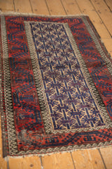 Vintage Belouch rug with navy geometric guls and cherry red border featuring hook and latch details.