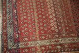 Antique Persian Hamadan rug corner with ruby red field, diminutive boteh, and navy-ivory border.