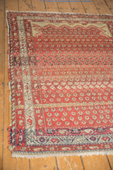 Corner of antique Hamadan rug with distinctive ruby red diminutive boteh field and geometric navy blue border.