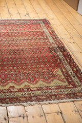 Antique Hamadan rug's unique asymmetric Mehrab end, showing ruby red abrashes and ivory.
