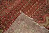 Corner of antique Hamadan rug shows foundation, fringe, ruby boteh, and saffron asymmetric overlay.