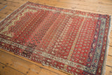 Hamadan rug field with staggered ivory boteh motifs, rich abrashes, and navy geometric border.