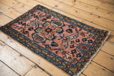 Vintage Lilihan rug: blush floral field, blue triple border, and fringed end.