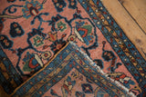 Folded vintage Lilihan rug corner: blush field, plush pile, blue vine borders, floral buds.