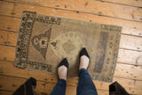 Vintage distressed Oushak rug showing soft low pile and tonal abrashes in beige and brown.