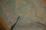 Distressed vintage Turkish Oushak runner with even wear, seafoam green pile, and secured edge.