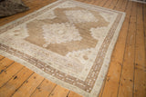 Distressed vintage Oushak rug detail, showcasing abrashed coffee brown and antique ivory tones.