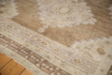 Vintage Distressed Oushak carpet's low pile, revealing stepped patterns in pale coffee, ivory, and mauve.