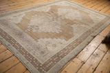 Distressed Oushak rug border, showcasing low pile and pale coffee and mauve details.