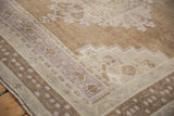 Vintage Distressed Oushak rug corner showing geometric patterns, low pile, and muted mauve and beige tones.