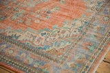 Distressed Oushak rug corner with tangerine, pale blue, ivory floral vinery.