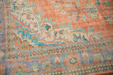 Distressed hand-knotted Oushak detail with tangerine, ivory, and pale blue vinery patterns.
