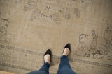 Distressed Oushak rug with sand, beige, and faded dark brown motifs showing even wear.