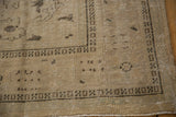 Distressed texture with a dark brown geometric border on a vintage Oushak rug corner.