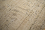 Worn pile of vintage Oushak carpet, with faded sand and brown blossomed motifs.