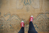 Distressed vintage Oushak rug section with faded sand tones and mallard green European vines.