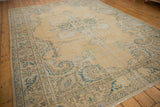 Distressed vintage Oushak rug with European stylized border, scrolling vines, and serrated contour.