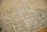 Distressed Oushak rug border detail with European scrolling vines in mallard green and brown.