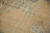 Distressed Oushak carpet detail, highlighting worn ivory texture and faded mallard green.