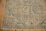 Distressed Oushak rug featuring European scrolling vines and serrated geometric border.
