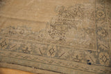 Vintage distressed Oushak rug featuring faded field motif, silver border, and visible foundation.