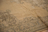 Distressed Oushak carpet: muted sand pile, even wear, and faded traditional border pattern.