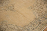 Worn sand field with faded silver and coffee brown patterns on a distressed Oushak pile.