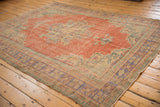 Distressed Oushak carpet corner, showing even wear, faded brick red, pale blue, and mint.