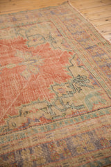 Textured low pile of vintage Oushak rug with pale brick red, mint green.