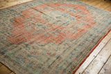 Fully secured side edge of the vintage Oushak rug, showing worn pile and faded cherry red.