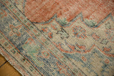 Distressed Oushak pile texture showing knot wear, faded cherry red and blue patterns.
