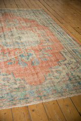 Decorative texture of this distressed Oushak carpet, showing faded red, sky blue, and foundation wear.