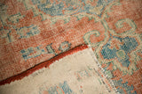 Faded cherry and blue distressed Oushak pile, showing hand-knotted reverse and secured side.