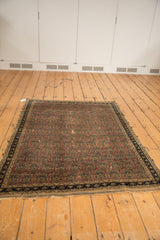 Detail of antique Afshar rug: aubergine allover botehs, navy border, and aged, threadbare wear.
