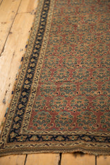 Antique Afshar rug corner showing aubergine field, unique boteh design, and navy geometric border.
