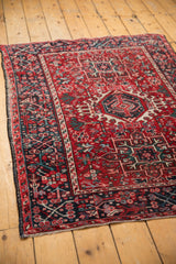 Karaja rug corner detail: navy geometric border, red field with blush and mallard vinery.