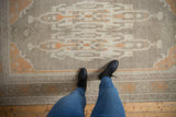 Distressed Oushak rug with ivory, platinum, and pale tangerine turtle-crab style border.
