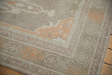 Vintage distressed Oushak rug corner showing low pile and pale tangerine turtle-crab border.